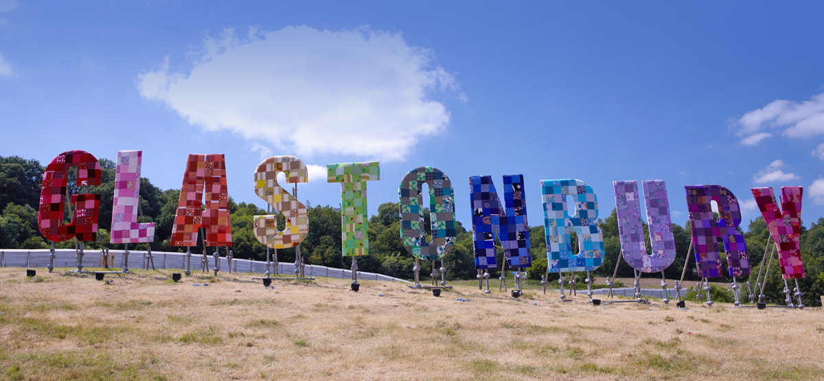 Glastonbury Festival is the most magical place on earth. This rainbow sign is famous worldwide. Come and stay with us for Glastonbury Festival accommodation!